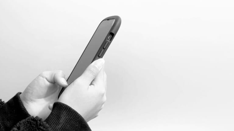 スマホで写真設撮影する人の手元を写した写真|車検証&自賠責保険証のコピー積載はNG? バイクに積載義務のあるものまとめ