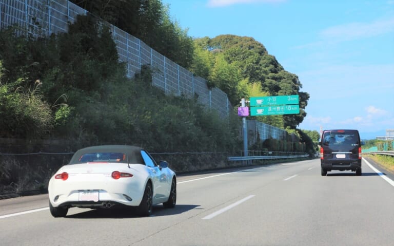 高速道路を走行する白いクルマの写真|雨の日に高速道路が一般道よりも走りやすく感じるのは、路面が特別な仕組みだから