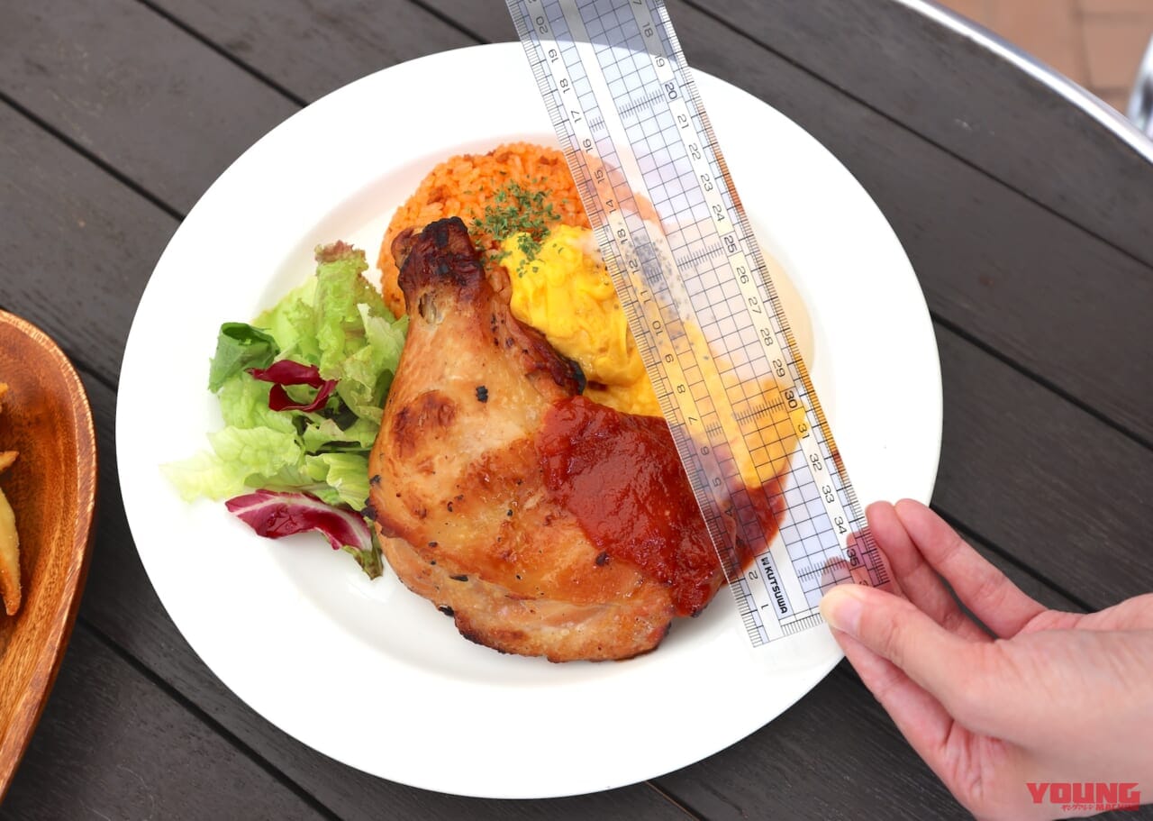 プレート料理に乗ったチキンレッグのサイズを定規で測っている写真|【MotoGP日本GP 10/4~6開催!】会場限定グルメをひと足先にレポート!