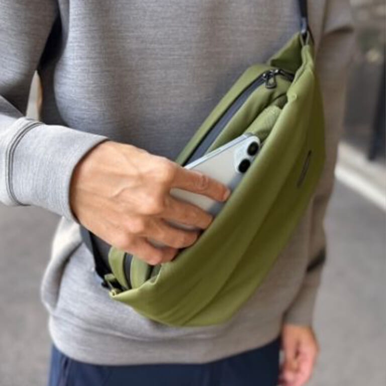 QUICK PACK Traspoの機能、ファスナーレスポケット、スマポからスマートフォンを取り出す画像|「これ神アイテムでは?」「ありそうでなかった…」便利機能を搭載で、防水性能も高くカラバリ豊富。手放せなくなること必至のバッグを紹介!