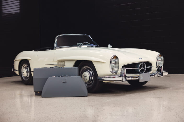 1963年製の、白いボディのメルセデス・ベンツ300 SLロードスターと、その横に置かれたオプションの専用ケース｜「見た目はエレガントなデザインだが…」一皮めくるととんでもない性能！ 63年前に作られた究極のストリート・レーサー［メルセデス・ベンツ 300SL］を紐解く