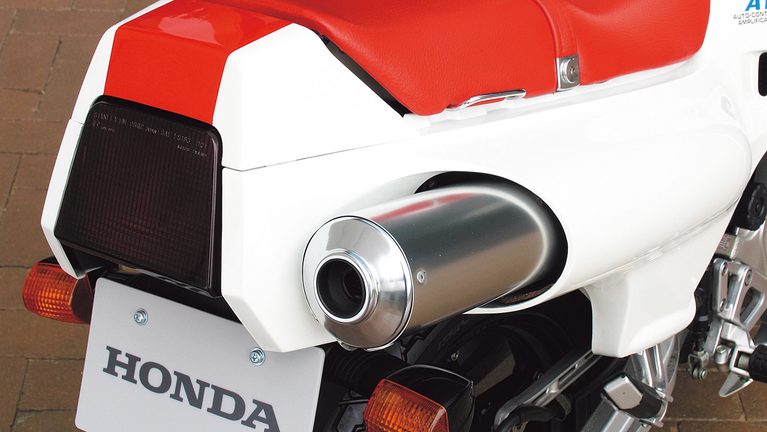 ホンダのNS250Rの、右側のサイレンサー｜「街なかで乗るのはひたすら苦行…」しかし峠では性格が豹変！ 42年前のホンダの名車。滑からな形状のカウルが印象的だった［NS250R］