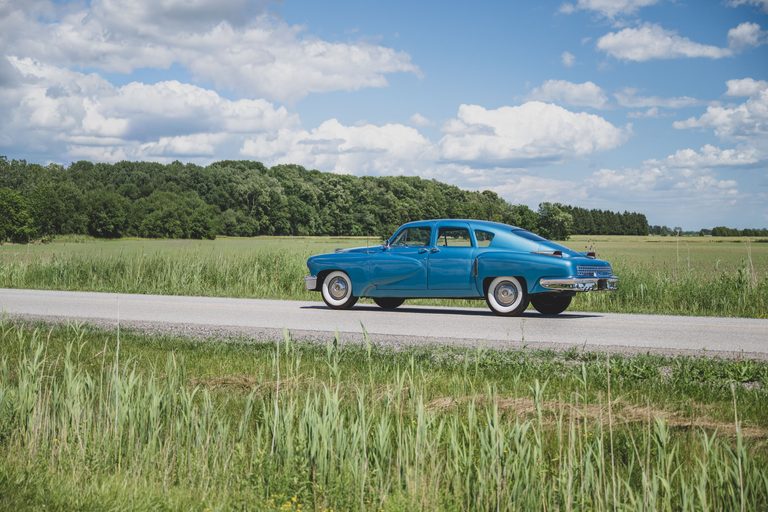 道路に停車する1948年製タッカー'48の左側面｜「一体なぜ…」国をも巻き込んだ妨害工作でわずか51台で消えた…。極めてレアな丸目3灯のフロントマスク。流線型ボディが美しい70年前の革新的名車［タッカー’48］を紹介