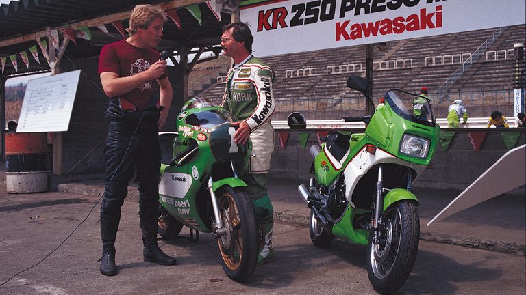 カワサキのKR250の発表会の写真。アントン・マンクとレーサーのKR250が並ぶ｜「80年代デザインが今見ると新鮮…」42年前に登場したカワサキの名車。変態的すぎるメカニズムを採用し、今もカルト的な人気を持つ［KR250］を紹介
