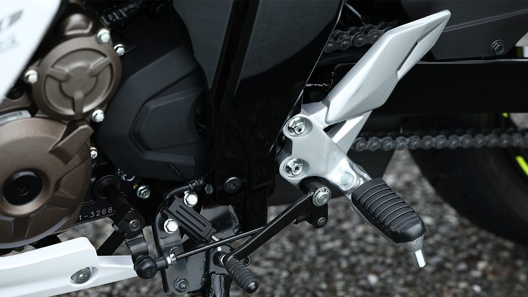 ステップバーにはラバーを装着｜コスパ最強の250ccフルカウル！スズキ「ジクサーSF250」に全日本ライダー岡崎静夏が試乗「曲がりすぎない」ハンドリングと意外すぎるツアラー適性を徹底インプレ